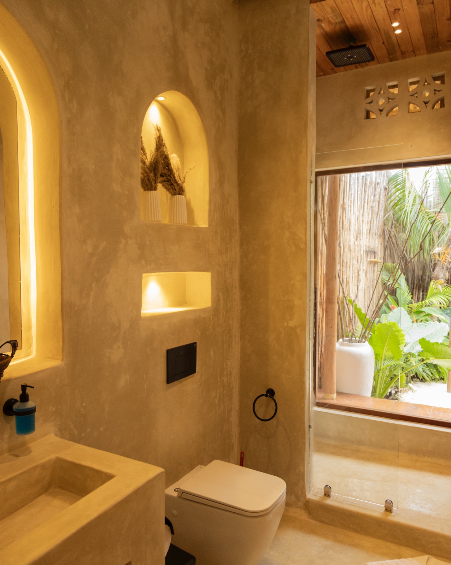 Plaster bathroom with backlit arched niches and a cast basin