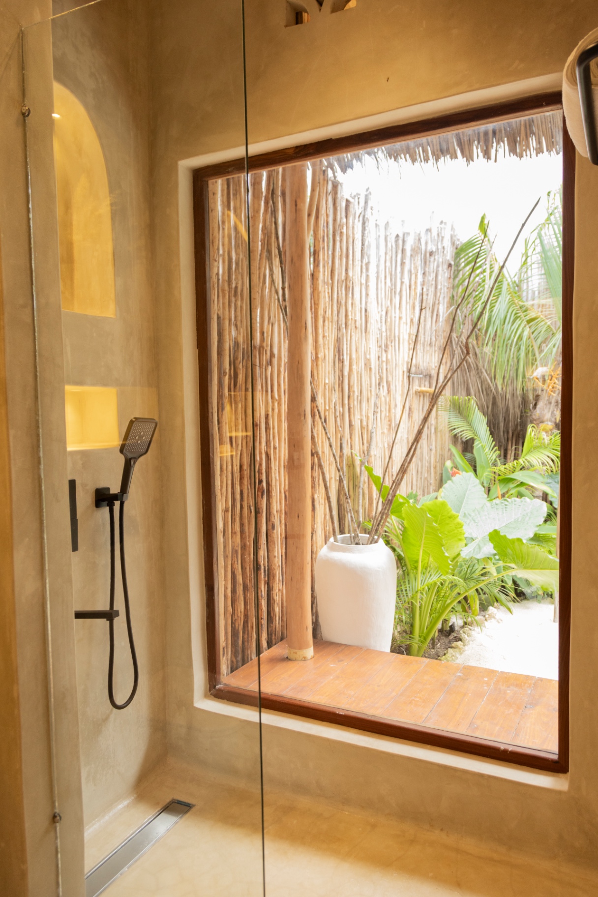 Walk-in plaster shower with a picture window onto a private planted courtyard